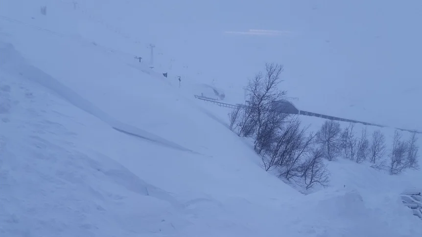 Här är det blåsigt och snö. Man har inte jättebra sikt. De flesta håller sig inne idag, säger Lisa Källviks som kan se det här när hon tittar ut genom sitt fönster i Riksgränsen.