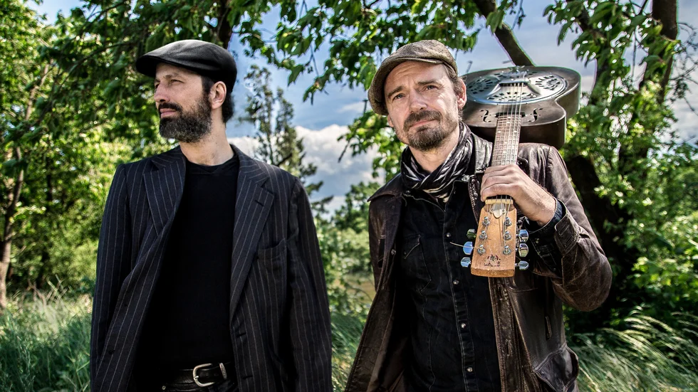 Munspelaren Holger Daub och gitarristen och sångaren Tim Lothar besöker Motala den 26 oktober. Med sig har de tubaspelaren János Mazura.