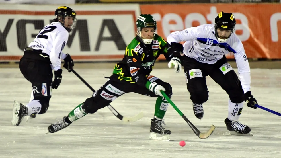 Simon Karlsson (t h) jobbar för att nå bollen i matchen mot Frillesås på Sjöaremossens isbana.