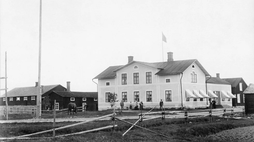 Frans Fridolf Jansson med familj poserar 1898 framför sin handelsfastighet. Med arkitektur har det alltid funnits en mening. I ett lantligt Norrbotten uttryckte detta besuttenhet på 1890-talet. Fastigheten fick en annan fortsättning som tuberkulosanstalten Hälsan 1906-1947. Byggnaden riven i maj 2020.