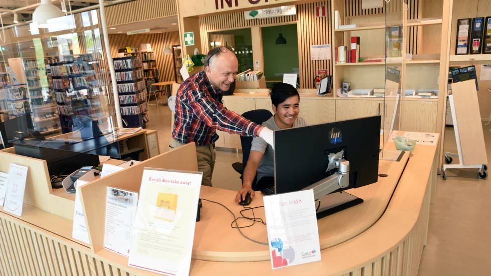 Bibliotekarie Eric Hammarström tillsammans med Evazali Kohanzadeh som efter en dramatisk flykt från Afghanistan kom till Sverige och Finspång för sex år sedan, när han var 14 år. 