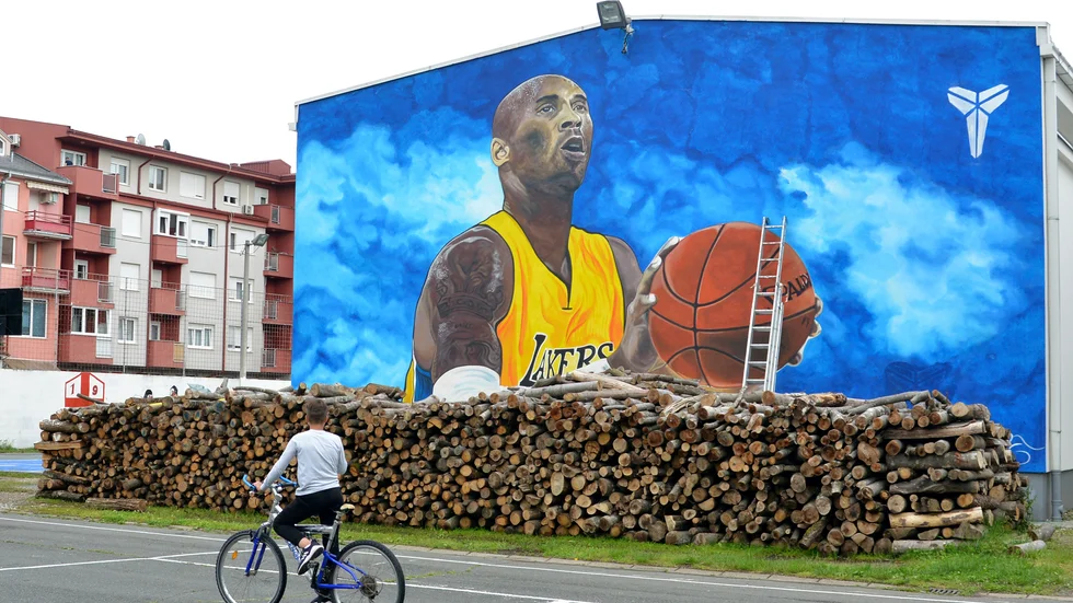 En cyklist betraktar den stora väggmålningen av basketlegenden Kobe Bryant i Bosanska Gradiska i Bosnien-Hercegovina.