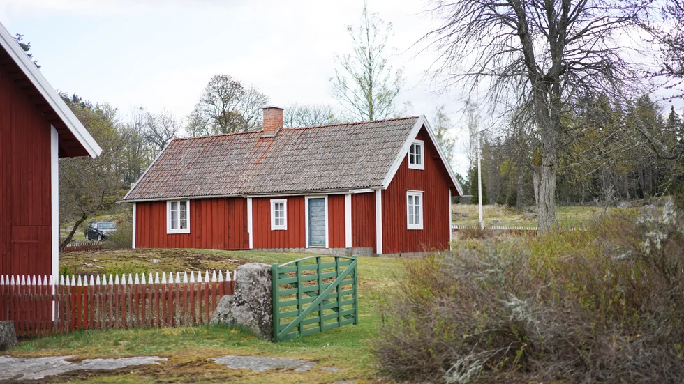 I mitten på 1700-talet möttes man inte av den rödmålade gården, staketet eller trädgården. Istället stod där en grå timrad stuga. 
