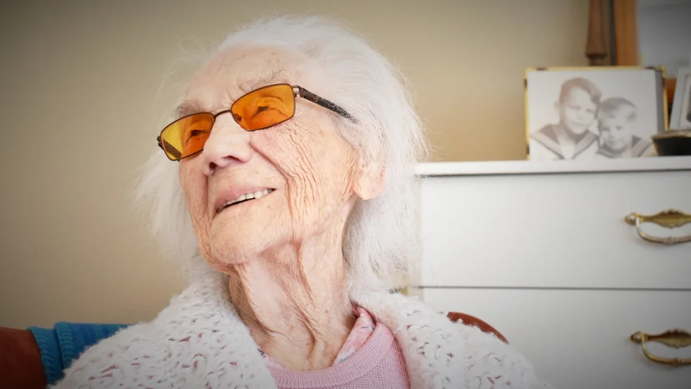 Signe Lundqvist, 110 år, bor på äldreboendet Västergården i Svartbäcken. I bakgrunden syns ett foto på hennes två söner.