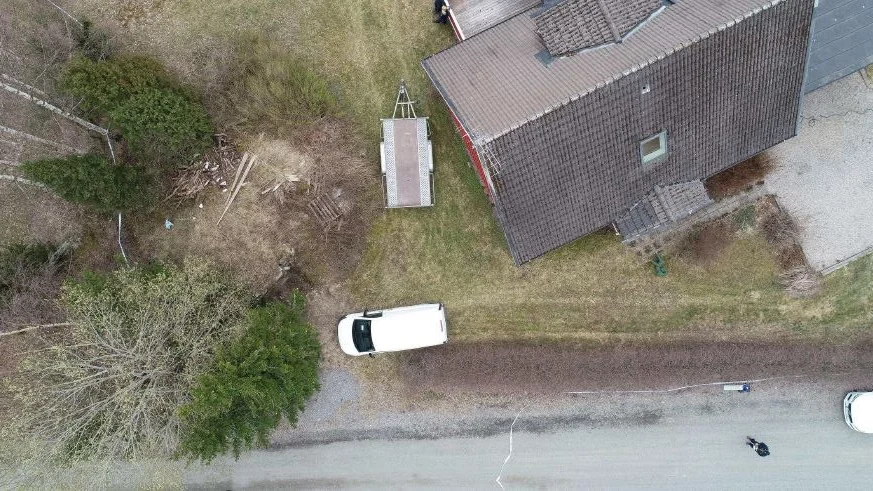 Från polisens rekonstruktion vid huset som kvinnan hyrde. Här har man försökt avgöra hur bilen och släpvagnen stått i förhållande till jordkällaren (vid buskaget) där åklagaren menar att den döde låg.