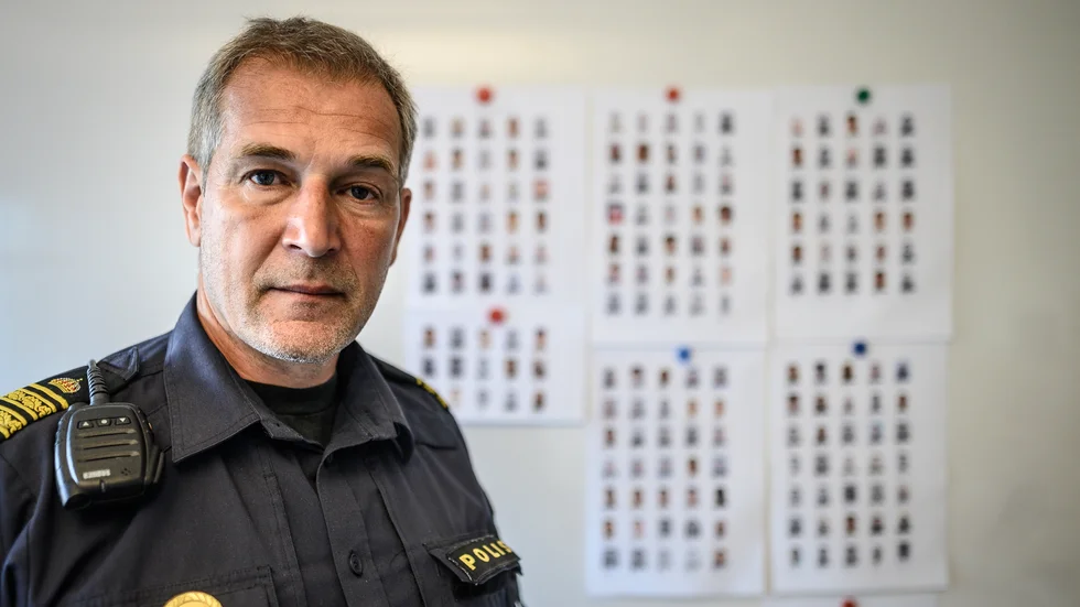 Bakom Daniel Larsson skymtar bilder på de 180 personer som polisen bevakar under Operation rimfrost. 