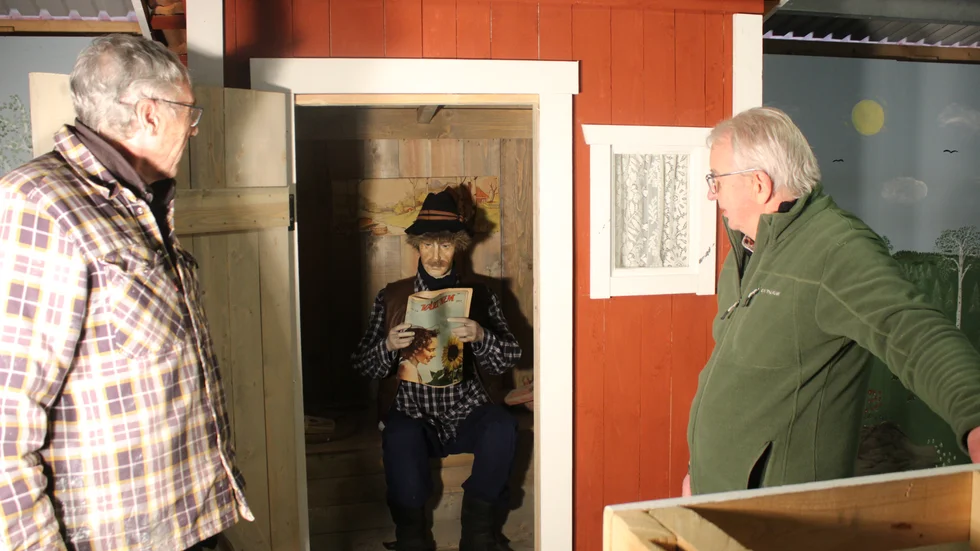 Här ses det nybyggda utedasset hos Ljusfallshammars lantbruksmuseum. Christer Eklund, till vänster, och Stig Andersson, kollar in gubben som satt sig tillrätta.