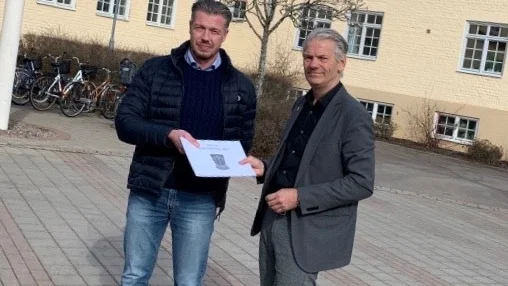 HC Wetterns ordförande Fredrik Jansson lämnar över 1 500 namnunderskrifter till Vadstena kommuns kommunalråd Peter Karlsson (M).