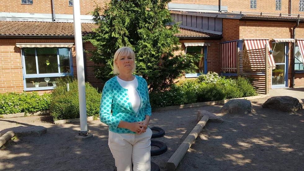 Karin Olanders framför tujan som Mohammeds familj kom med på skolavslutningen 2005 och som planterades då. 