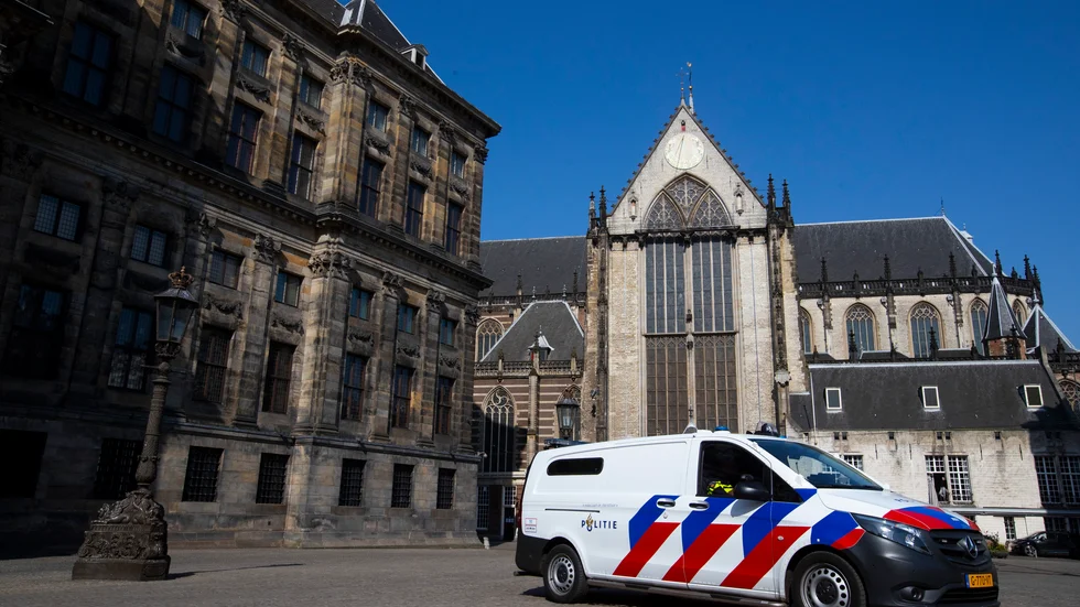 En polisbil håller ett öga på stillheten framför Kungliga slottet i Amsterdam (till vänster). Nederländerna är liksom merparten av världen näst intill nedstängt av coronaviruset. Arkivfoto.