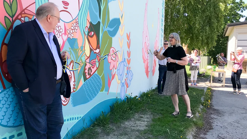 Kyrkoherde Anna Jarl fick äran att klippa bandet när den nya muralmålningen intill Kyrkan hus invigdes.