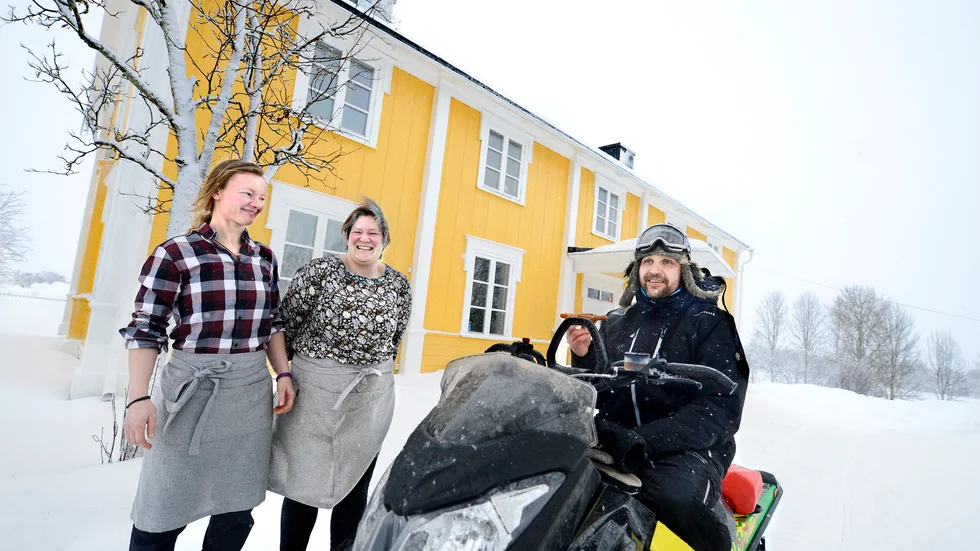 När snöandet gjorde det glest mellan skoteråkarna vid premiären av det nya skoterkaféet i Överkalix bjöds Mikael Beckman i Bränna att provsmaka en av korvarna. Bredvid står kaféets ägare Katharina Koch-Hartke och Johanna Heinrich.  