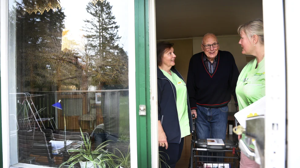 Hemtjänstbesöken är den enda fysiska samvaro Bertil Larsson, 95, har haft den senaste månaden. Anette Andersson och Cedda Cederlund försöker lätta upp tillvaron, bland annat med knepiga tankenötter.