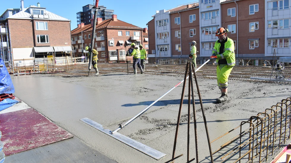 Mikael Hellberg jämnar till den våta betongen med en sloda. Här ska bli slätt som ett salsgolv.