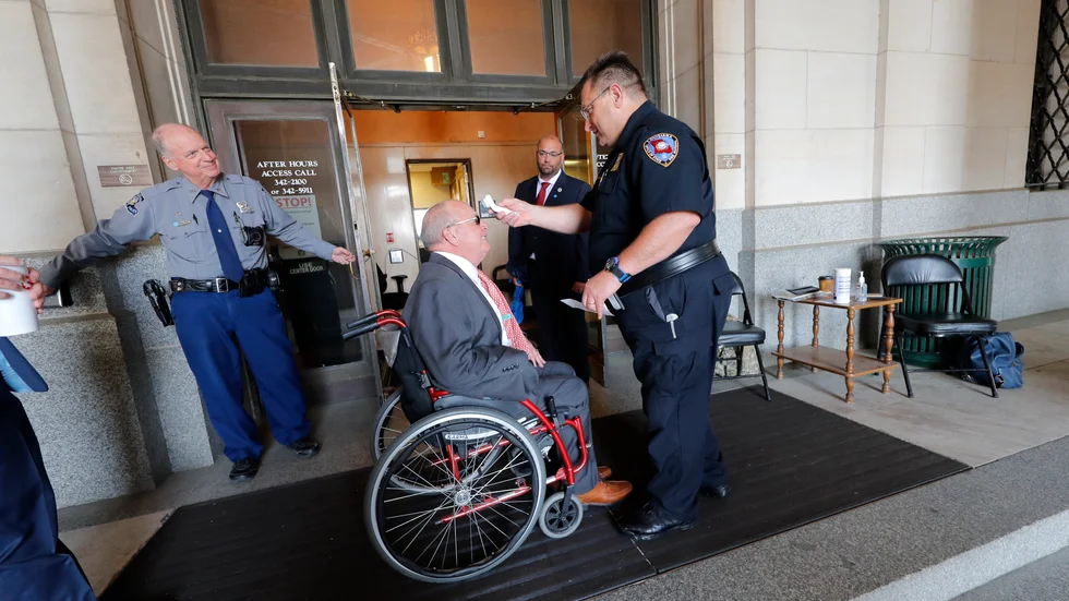 Delstatspolitikern Dewith Carrier får sin temperatur kontrollerad innan han går in i delstatskongresen i Baton Rouge i det virusdrabbade Louisiana.
