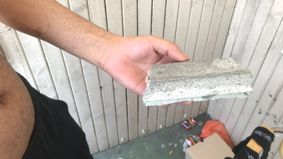 En decimeterlång betongbit träffade Father Poyani i nacken.