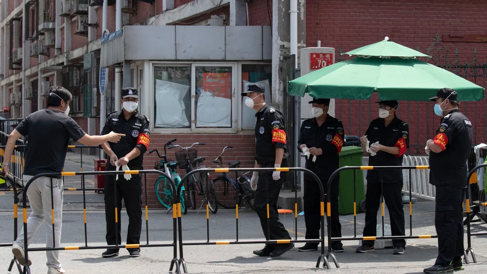 Säkerhetspersonal vid ett kvarter som stängts ned i Peking i samband med ett utbrott av det nya coronaviruset.