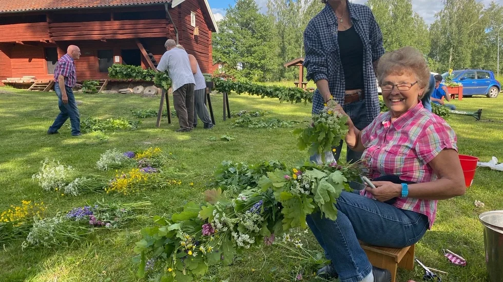 Ann-Britt Frost och Jana Anckarman hjälps åt att binda kransarna till stången.