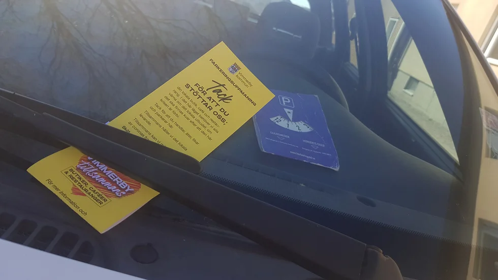 Kommunens parkeringsvakt kombinerar sitt vanliga jobb med att nu också lappa bilar med uppmaningen om att stötta den lokala handeln och restauranger. 