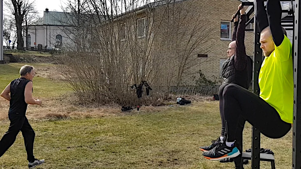 Knäböj i hängande position. Per och Christoffer kämpar på. I bakgrunden är Stig på väg tillnästa station.
