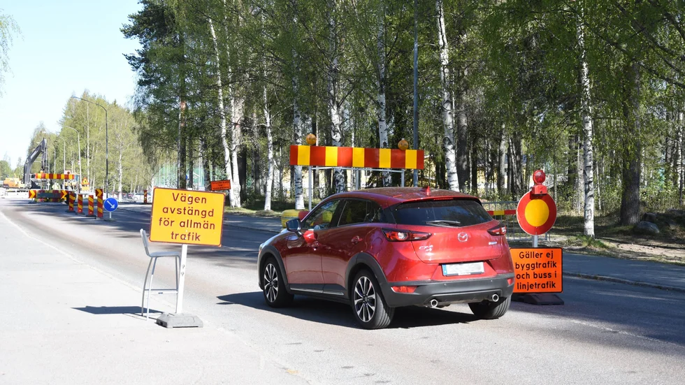 Bilar kör på Mjölkuddsvägen utanför Tunaskolan trots skyltar och flaggvakt. 
