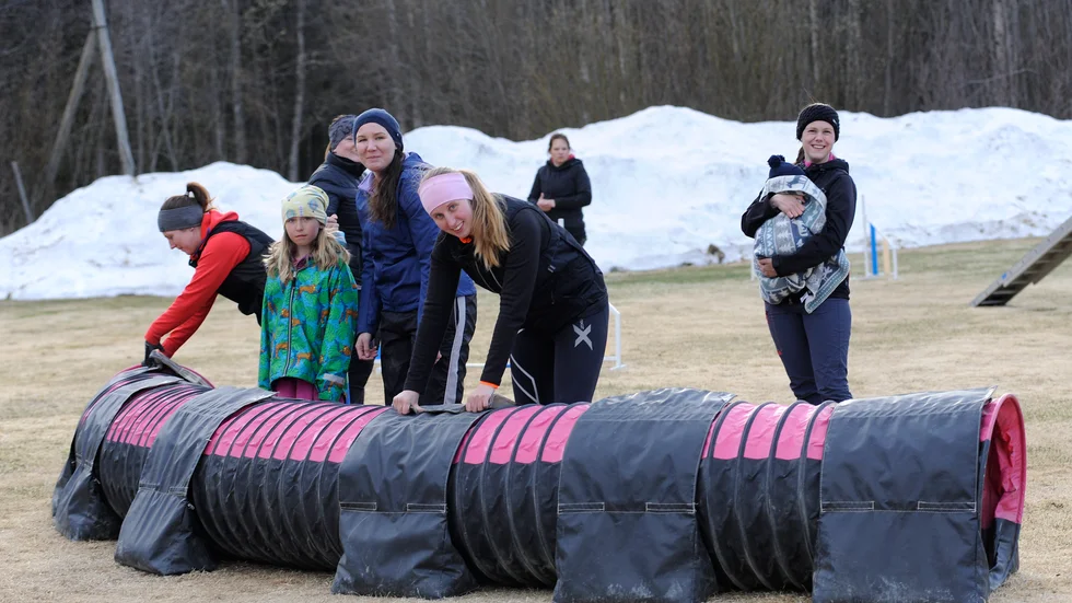 Lovisa Malm, Malva Björk, Josefine Björk, Linda Larsson och Sara Salsbring med lille Valter Salsbring i famnen, hjälps åt att bygga banan Pandemic som ingår i Corona Agility Cups fjärde delmoment.
