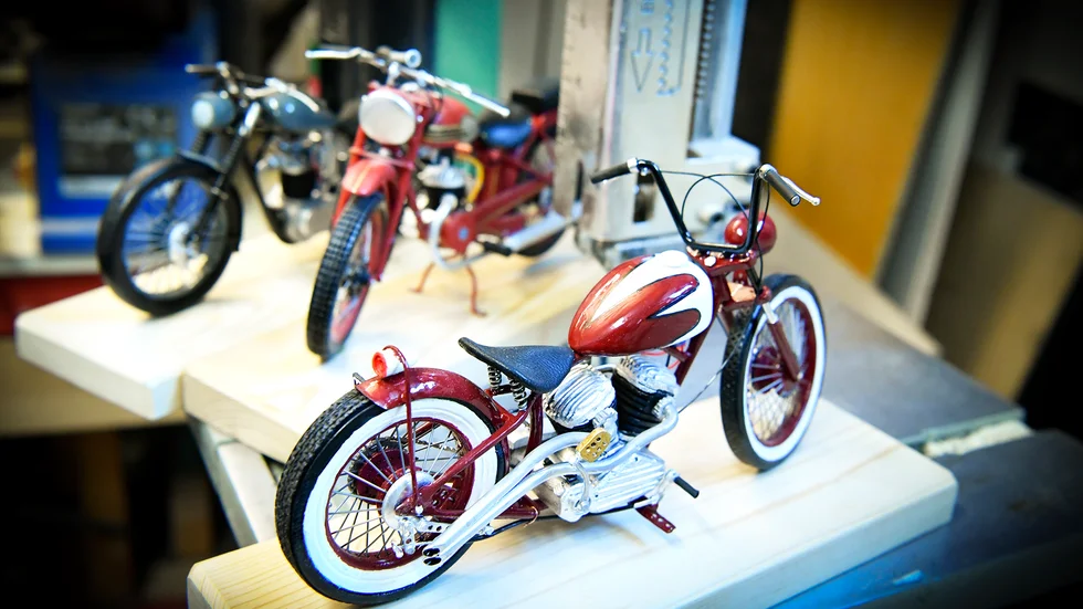 De små miniatyrmotorcyklarna är i skala 1:10. Närmast kameran en Bobber som är röd och vit. ”Det är mitt fritidsintresse att bygga de små modellerna och jag gör det på mitt eget sätt”, säger Kenneth Lundmark.