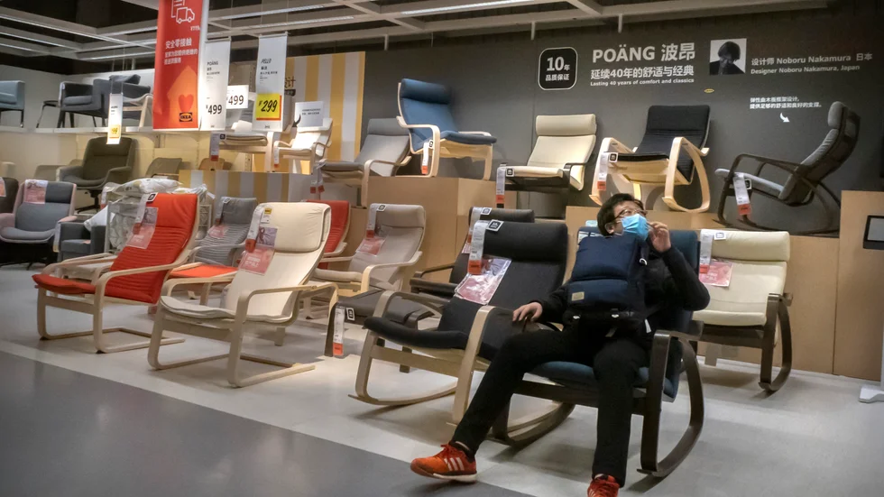 En man med munskydd provar en stol på Ikea i Peking. Arkivbild.