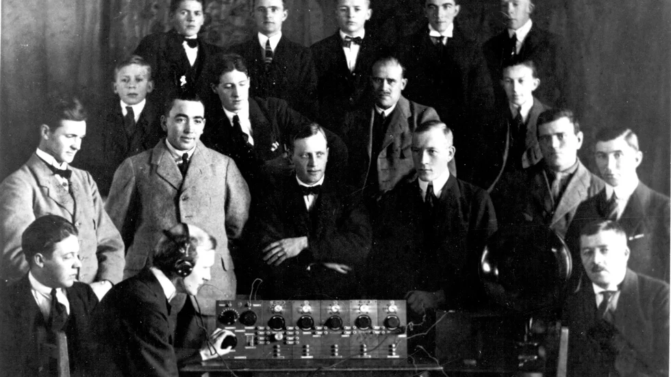 Här är medlemmarna i Arvidsjaurs Radioamatörklubb samlade kring sin apparat. Året är 1923. Översta raden fr.v. Per Stenlund, Arvid Arvius, Klas Stenlund, Einar Lenman, Vilhelm Pettersson.
Mellersta raden: Hugo Stenlund, Uno Lundström, Jonas Karlsson, Ivar Stenlund, Ernst Lenman.
Sittande: Carl Lindqvist, David Johansson (ledare och konstruktör), P.A Stenlund.
