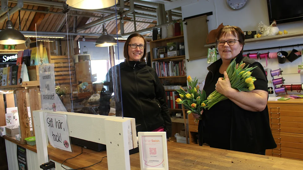 Linda Öhrvall och Leena­-Kaisa Linderson expedierar kunderna bakom en skiva plexiglas, för att minska smittspridningen.