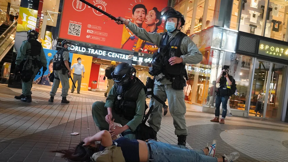Kravallpolis i Hongkong griper en demonstrant under en protest den 12 juni.