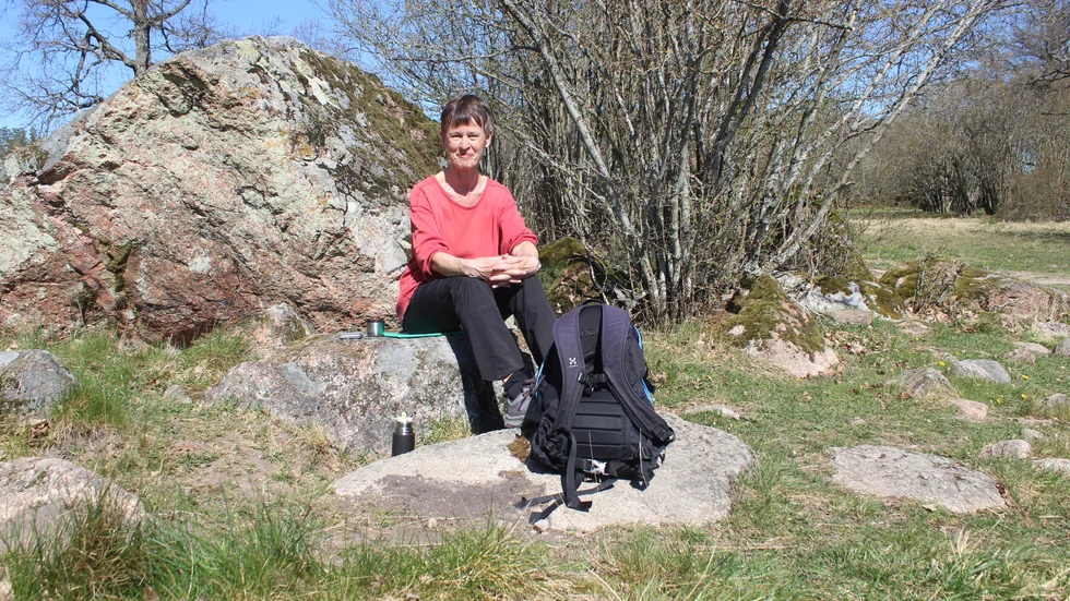 Siw stitter med sitt kaffe och sin radio och lyssnar till fågellivet på sjön.