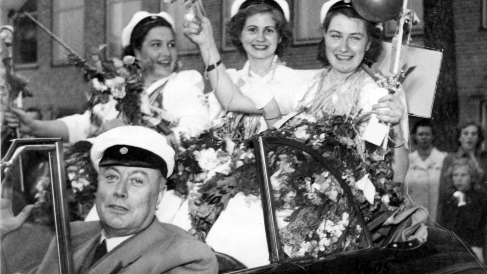 Advikat Julius Lindströmmed tre glada studentskor vid den första studentexamen i Läroverket, 17 maj 1949.

