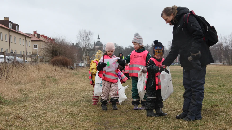 Love får hjälp av Marie Hammarsten att hålla upp påsen. Bakom skymtar förskolekompisarna Molly och Felicia.
