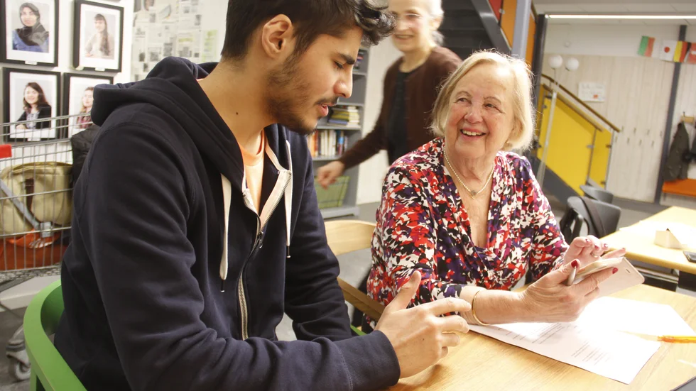 Eivor Jonsson får lära sig mer om Instagram av kursassistenten Omar Toukaj. Det är föreningen Ulvis som ger kursen i samarbete med bland andra Uppsala kommun och Studiefrämjandet. I bakgrunden syns projektledaren Stojka Lakic.
