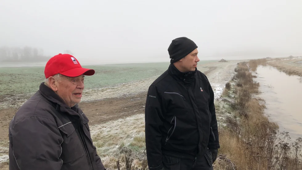 Far och son. Sture och Hans-Eric Fredriksson blickar ut över gårdens vattendränkta åkermark. Även närbelägna gårdar har drabbats av översvämmade åkrar och förstörd höstsådd.