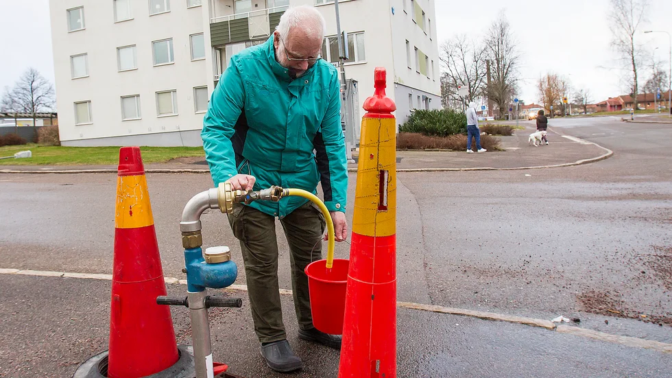 Bo Kaliff tappar upp vatten från en kran utanför huset. "Det har varit väldigt besvärligt", säger han om situationen.