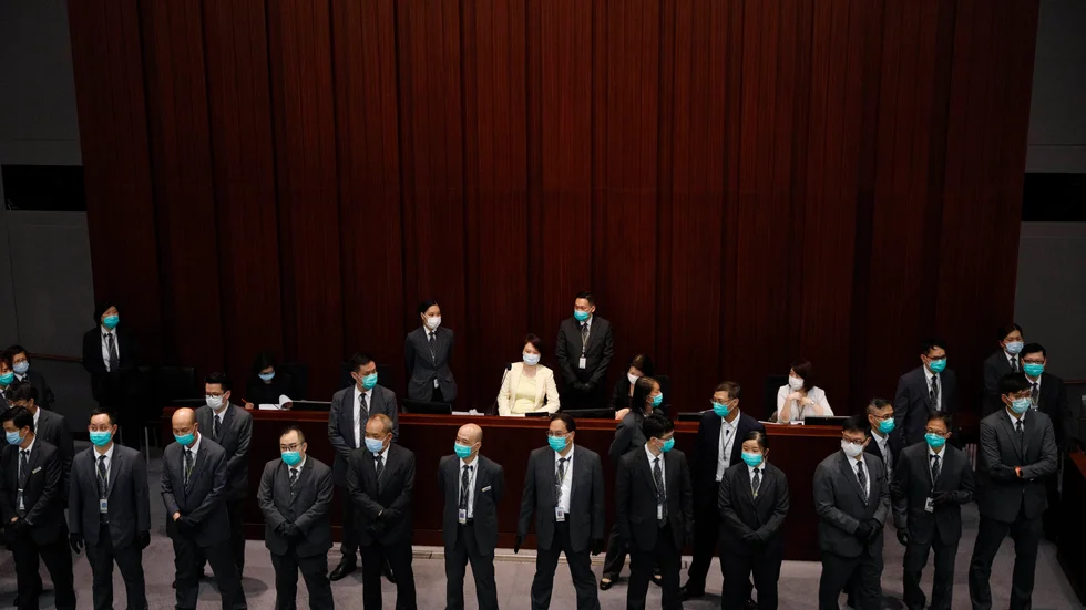 Sessionerna i Hongkongs parlament är ofta laddade tillställningar. Här skyddas den Peking-vänliga ledamoten Starry Lee av vakter under en förhandling i maj.