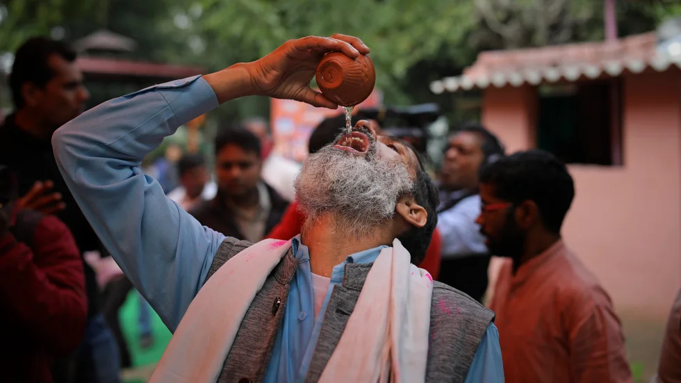 En man indisk dricker gaumutra, eller urin från kor, under ett evenemang i New Delhi i mars.