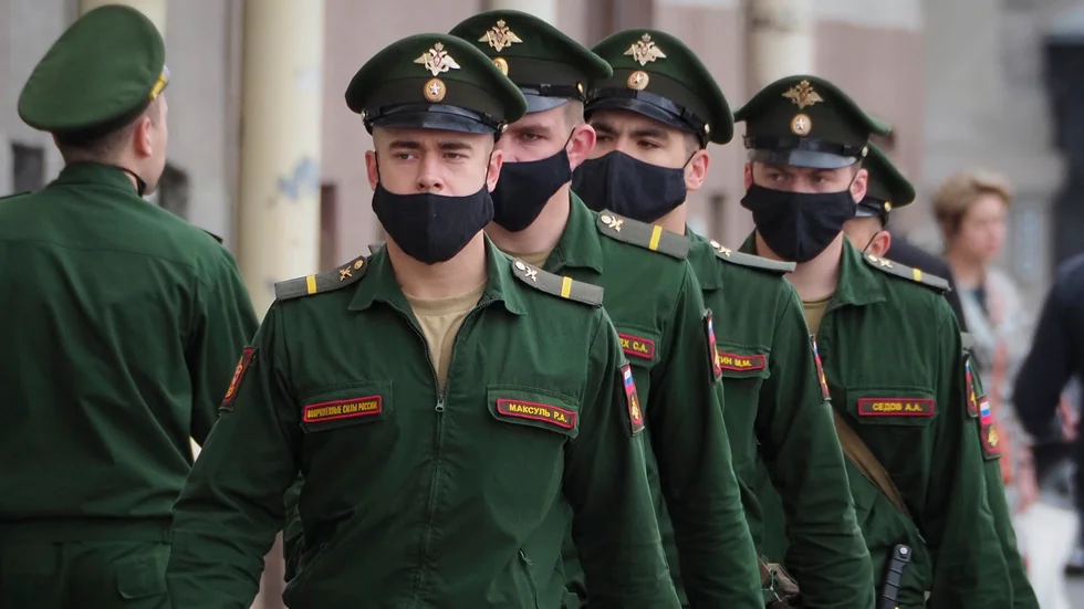 Soldater med ansiktsmasker marscherar i ryska S:t Petersburg. Landets dödstal är lågt i förhållande till antalet smittade.