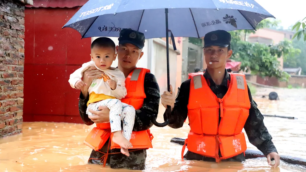 Ett barn evakueras tidigare i veckan i den översvämmade byn Qingyuan i Guangdong-provinsen i södra Kina.