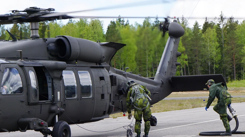 Nu går det undan! Martin Nilsson kommer springande med bränsleslangen, samtidigt helikopterpiloten förbereder tankningen.