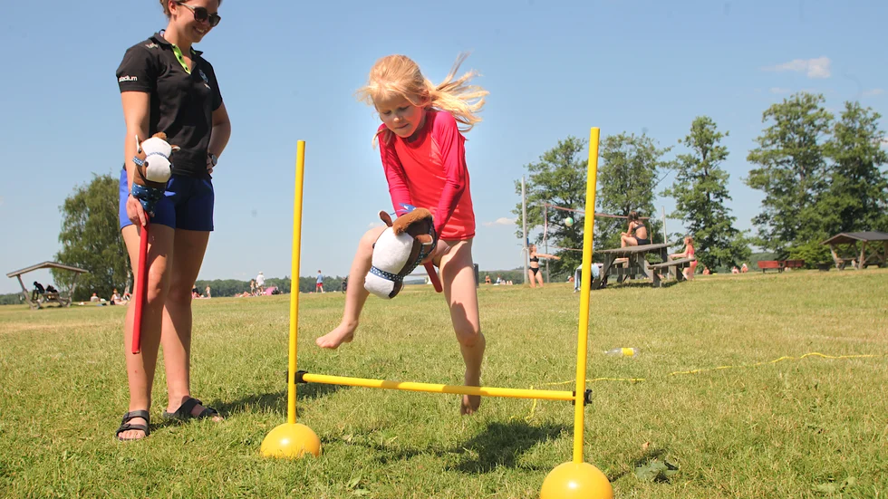 Lisa Forsberg, 6, har varit på Visholmen flera dagar den här veckan och provat aktiviteter som kubb, plockepinn och här hinderbanan – med käpphäst. I augusti börjar hon första klass på Finningeskolan.