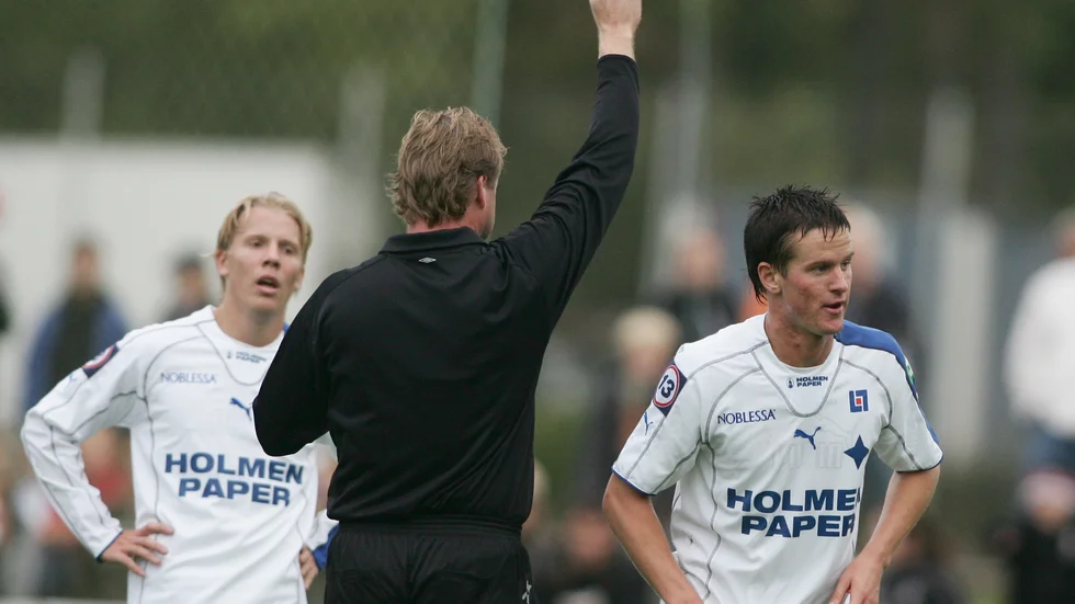 Andreas Dahlén får syna det gula kortet. Viktor Rönneklev ser på. 