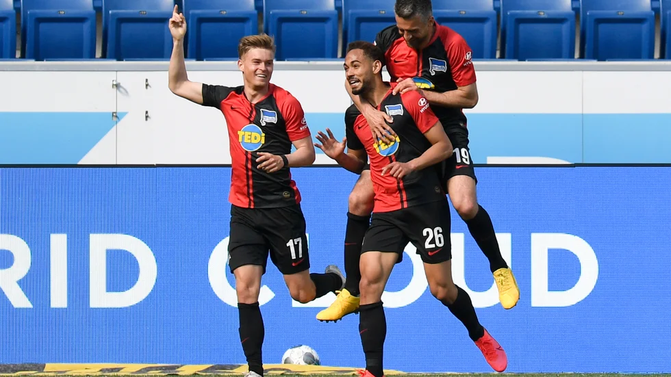Hertha Berlins Cunha Matheus, i mitten, gratuleras av Vedad Ibisevic, höger, i mötet med Hoffenheim – detta på ett sätt som strider mot Bundesligas direktiv angående distansering.