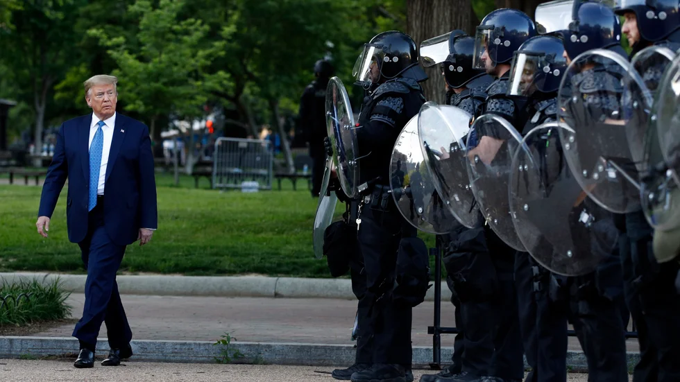 President Donald Trump passerar kravallutrustad polis i Lafayetteparken bredvid Vita huset.