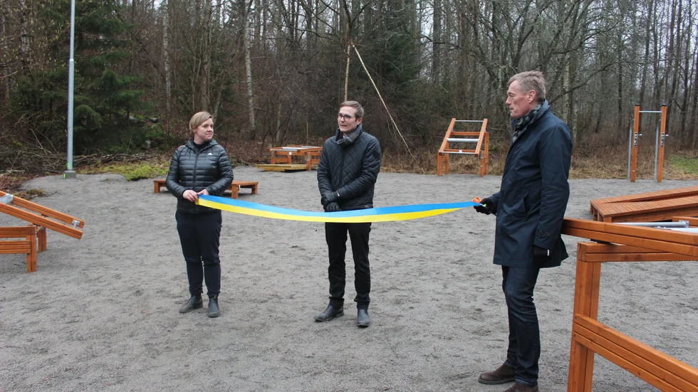 Samhällsbyggnadsnämndens ordförande Mikael Österling (L) inviger utegymmet genom att klippa bandet som Ida Härnström och Jimmy Bexell håller i.
