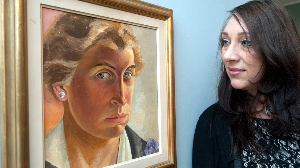 Marika Bogren framför ett av Tyra Lundgrens porträtt. Bilden är tagen i samband med den utställning som turnerade genom delar av landet för snart tio år sedan. 