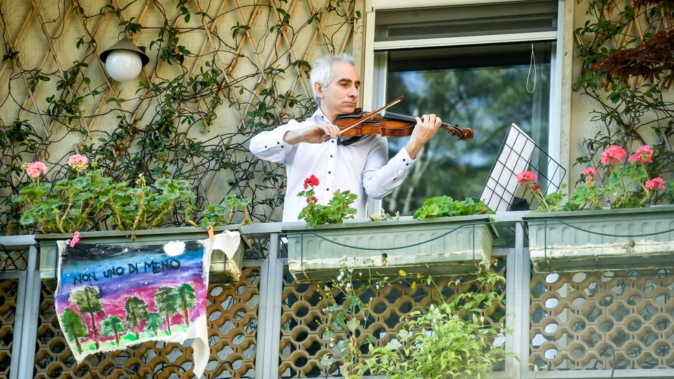 Damiano Cottolasso, violinist vid La Scalas filharmoniker spelar på sin balkong i Milano. Den berömda orkestern uppträdde på nytt vis för att delta i hyllningarna till landets vårdpersonal.
