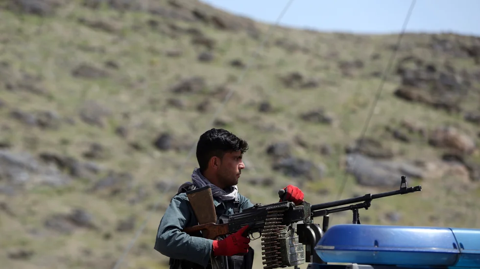En afghansk polis håller vakt vid en plats där en självmordsattack genomförts utanför Afghanistans huvudstad Kabul.
